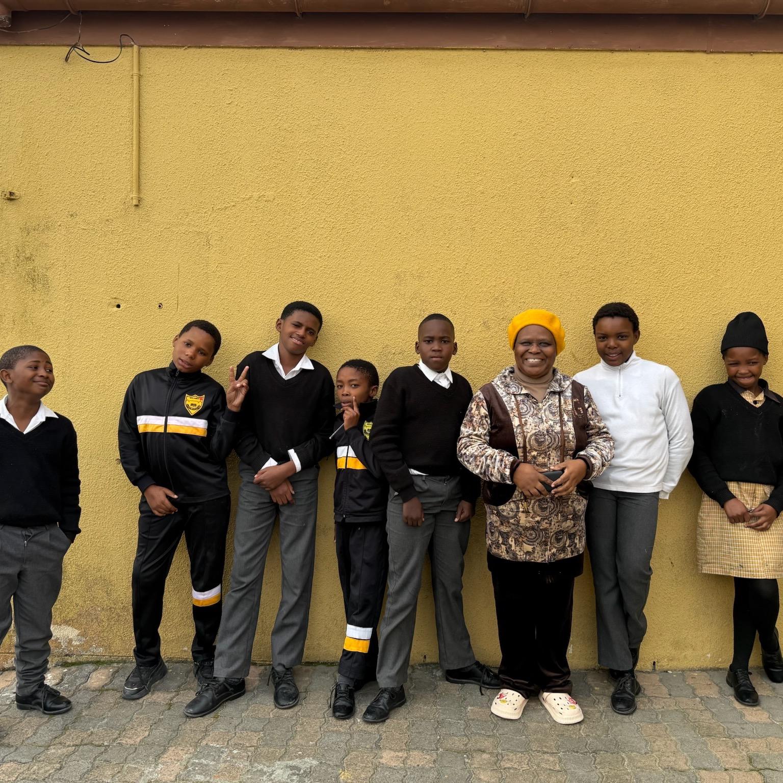 Students stand outside with "Mama Vuvu"